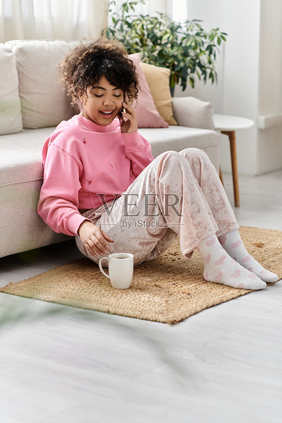 年轻女性在现代公寓里享受一个舒适的下午，品尝咖啡。照片摄影图片