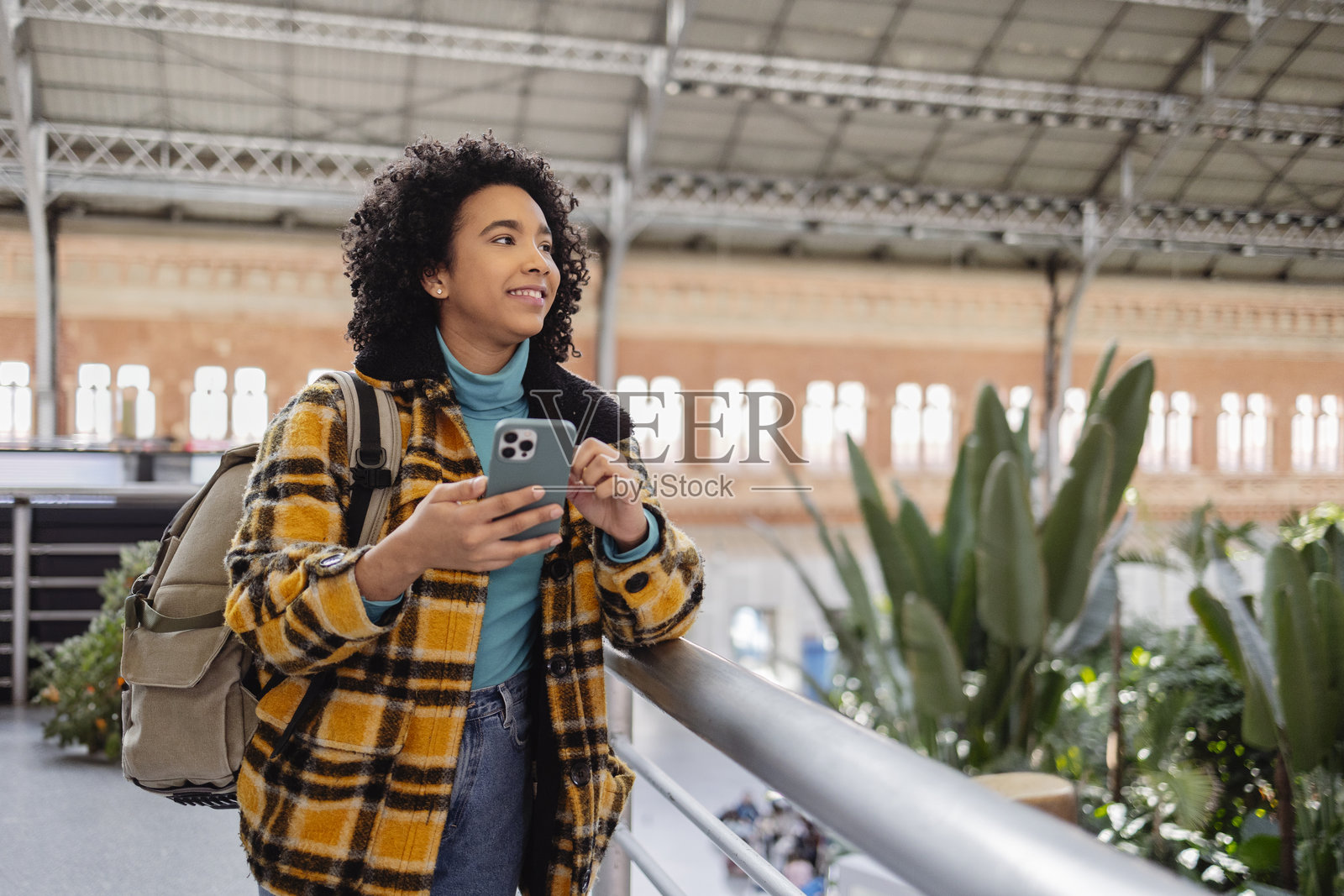 年轻旅行者在现代火车站使用智能手机照片摄影图片