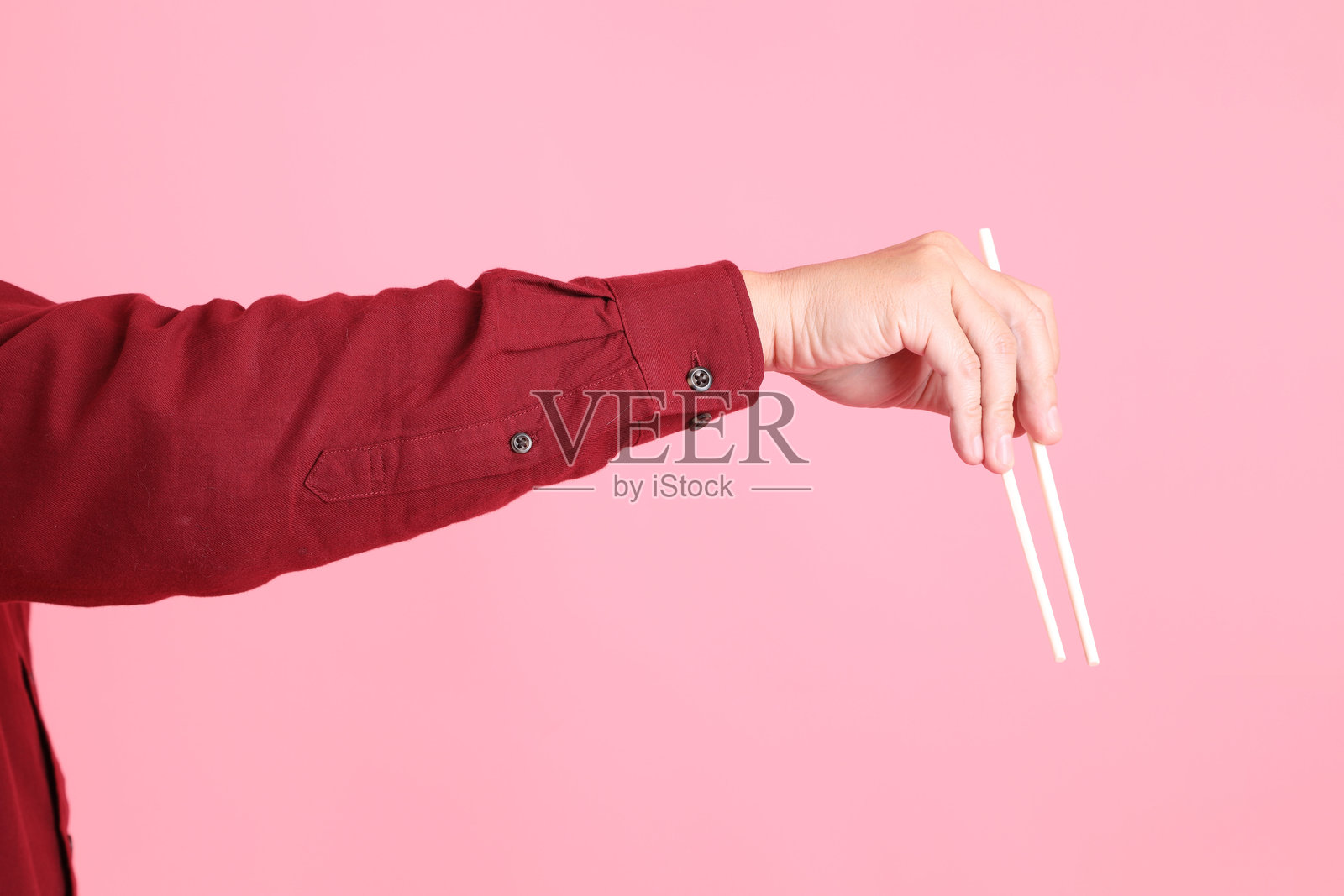 手握塑料筷子照片摄影图片