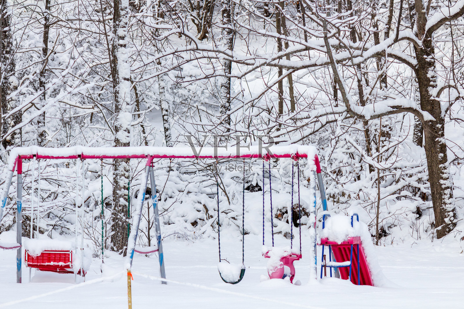 安静冬季森林环境中的雪覆盖游乐场照片摄影图片