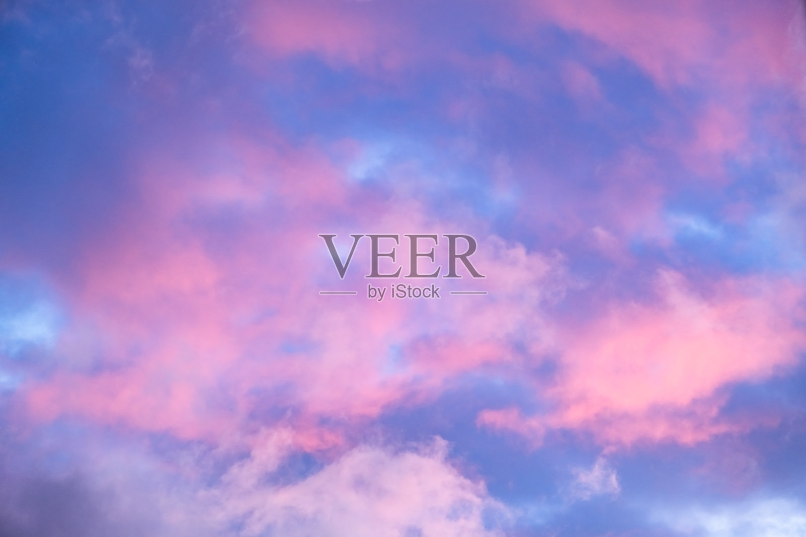 蓝色的晨空映衬着粉色的云朵。日出的云彩呈现香草色。自然之美。黄昏时分，黄金时刻。傍晚日落的细节。自然抽象。和平的概念。全景视图。照片摄影图片