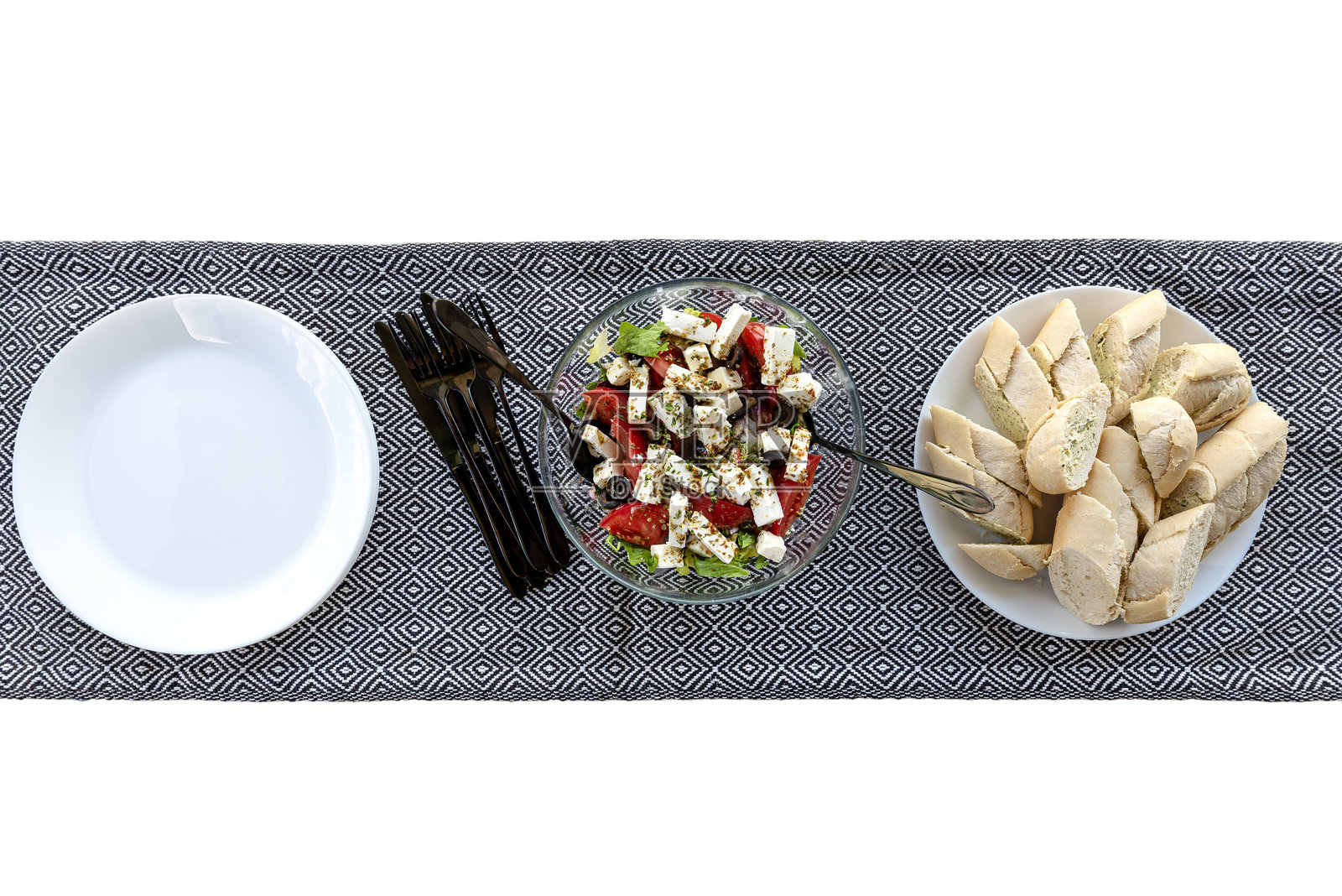 盛在玻璃碗中的蔬菜沙拉，配有菲达奶酪和多种蔬菜，放置在桌布上。照片摄影图片