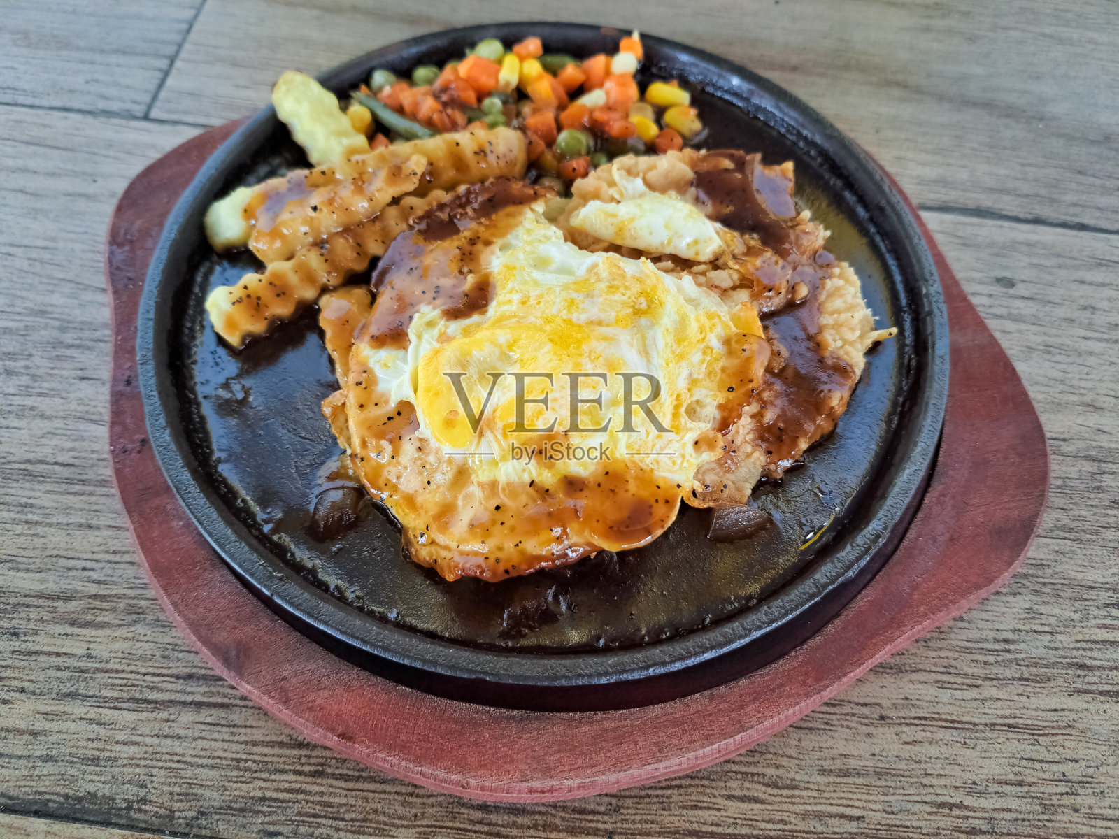 美味的脆皮鸡蛋牛排，配炸鸡肉、煎蛋、薯条、混合蔬菜和烧烤酱。菜单。照片摄影图片