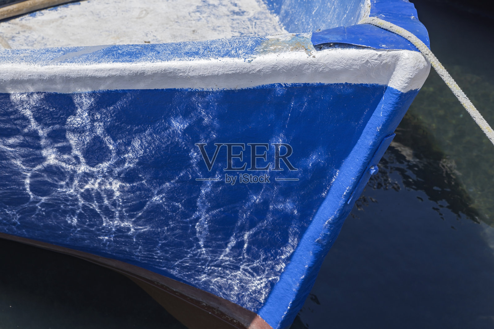 小蓝色渔船船头的水面倒影照片摄影图片