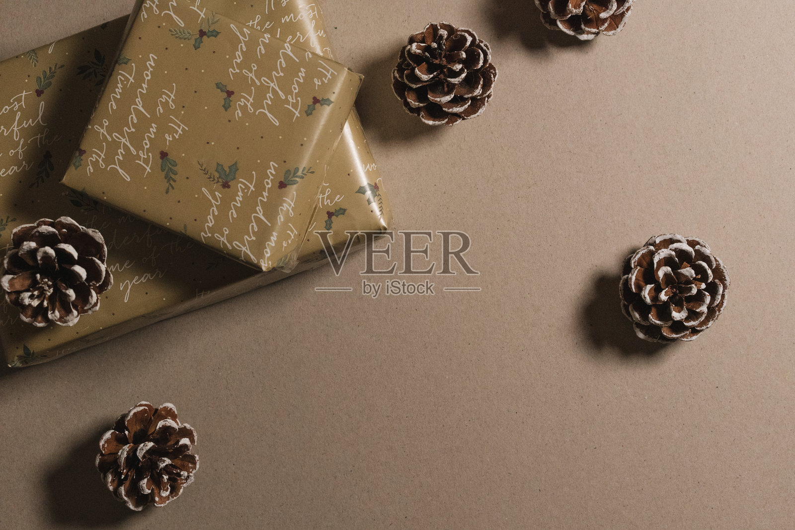 用金色纸张、装饰品和松果包装的圣诞礼物，适合节日庆祝。空白副本空间，样板，模板照片摄影图片