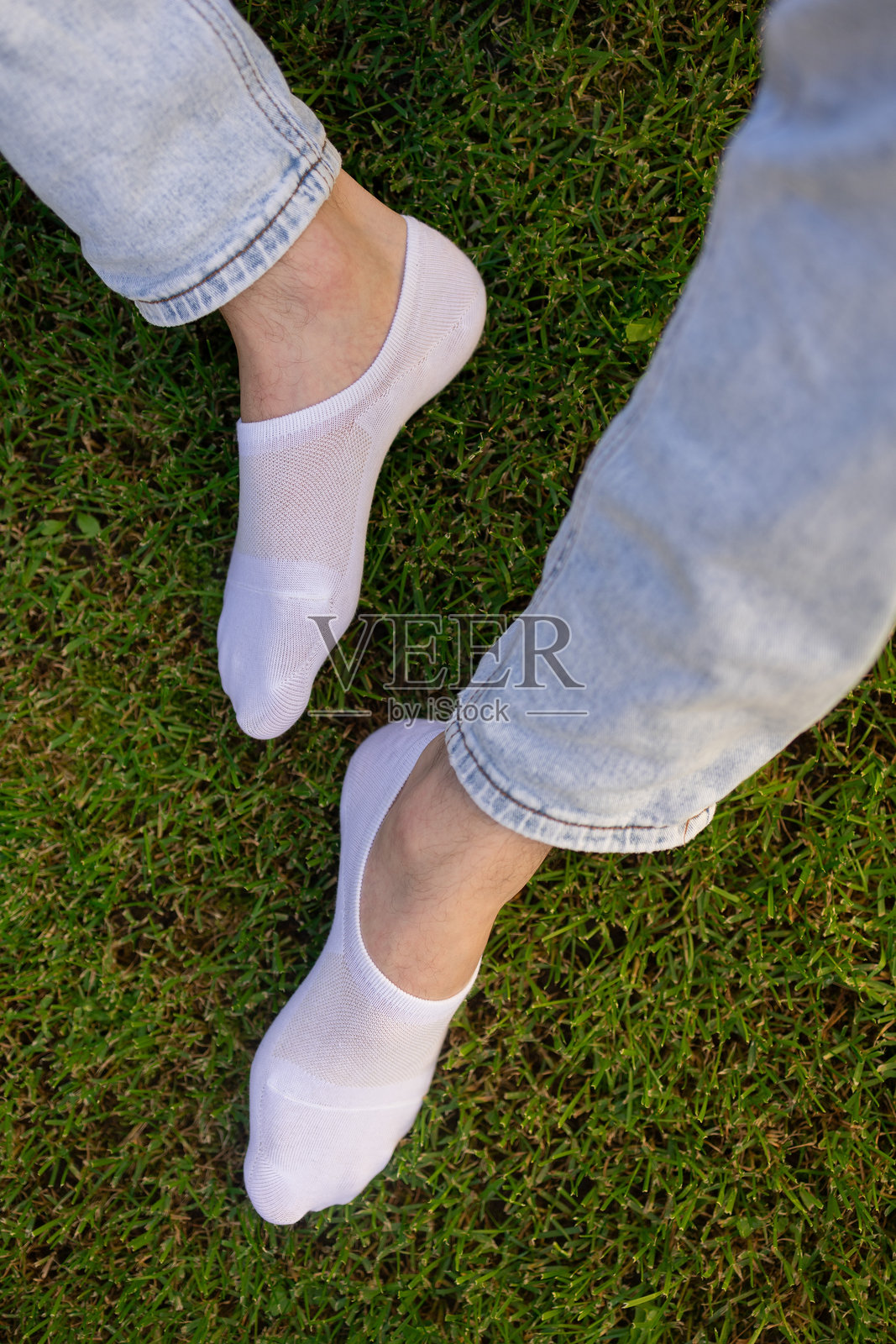 简单的白色男士袜子放在绿色草地的背景上照片摄影图片