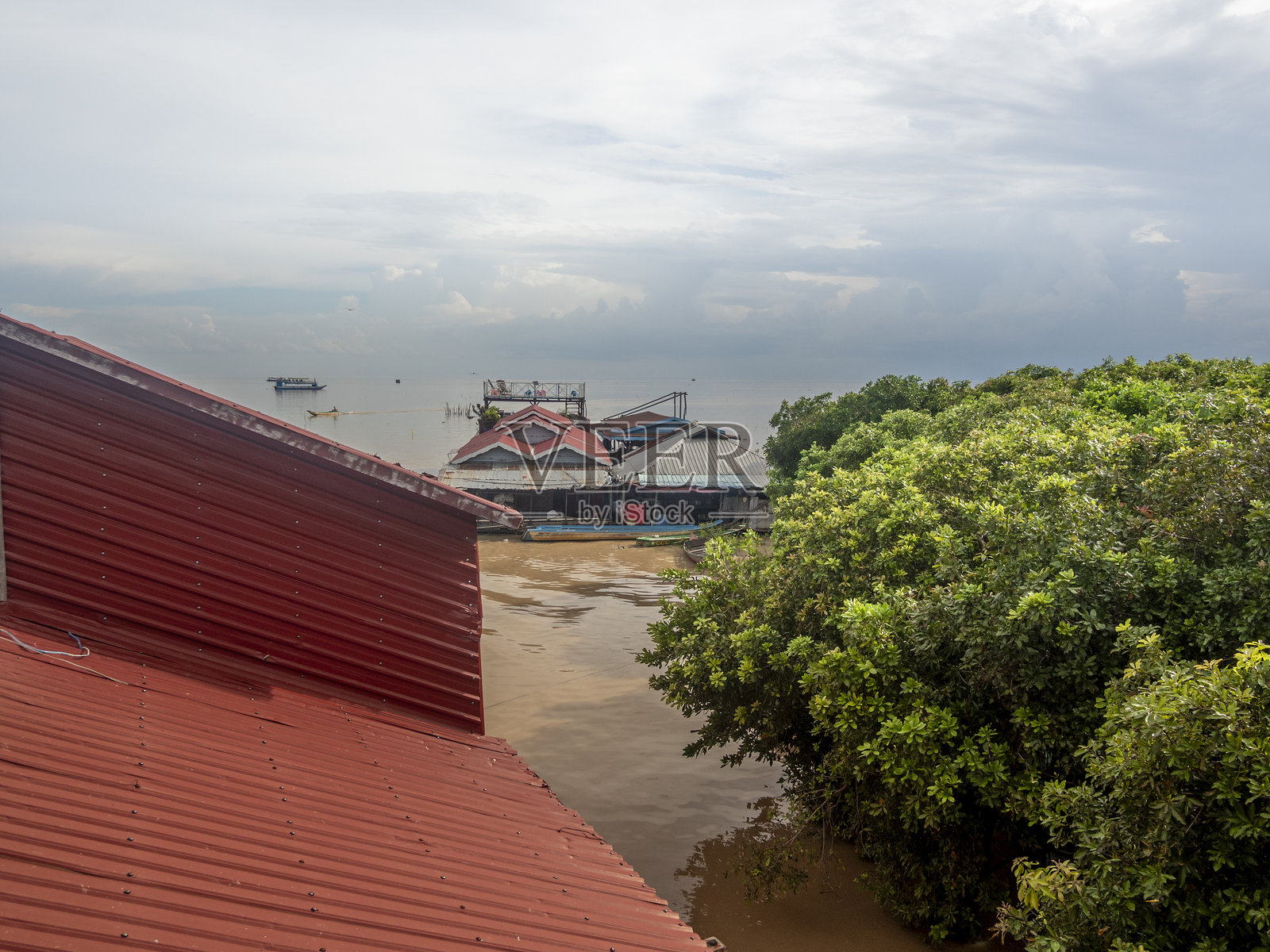 柬埔寨暹粒附近的高脚屋彩色村庄Kampong Phluk，渔船和渔网。照片摄影图片