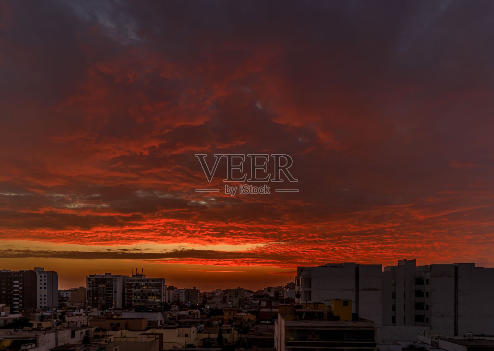令人惊叹的城市日落，秘鲁利马上空绚丽的红色云彩照片摄影图片