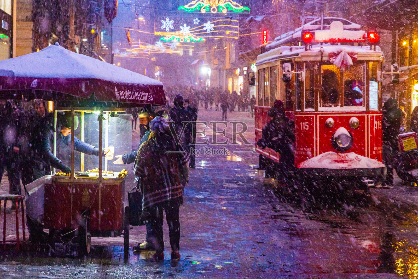 冬季的红色电车在伊斯提克拉尔街，塔克西姆贝尤鲁，伊斯坦布尔，土耳其照片摄影图片