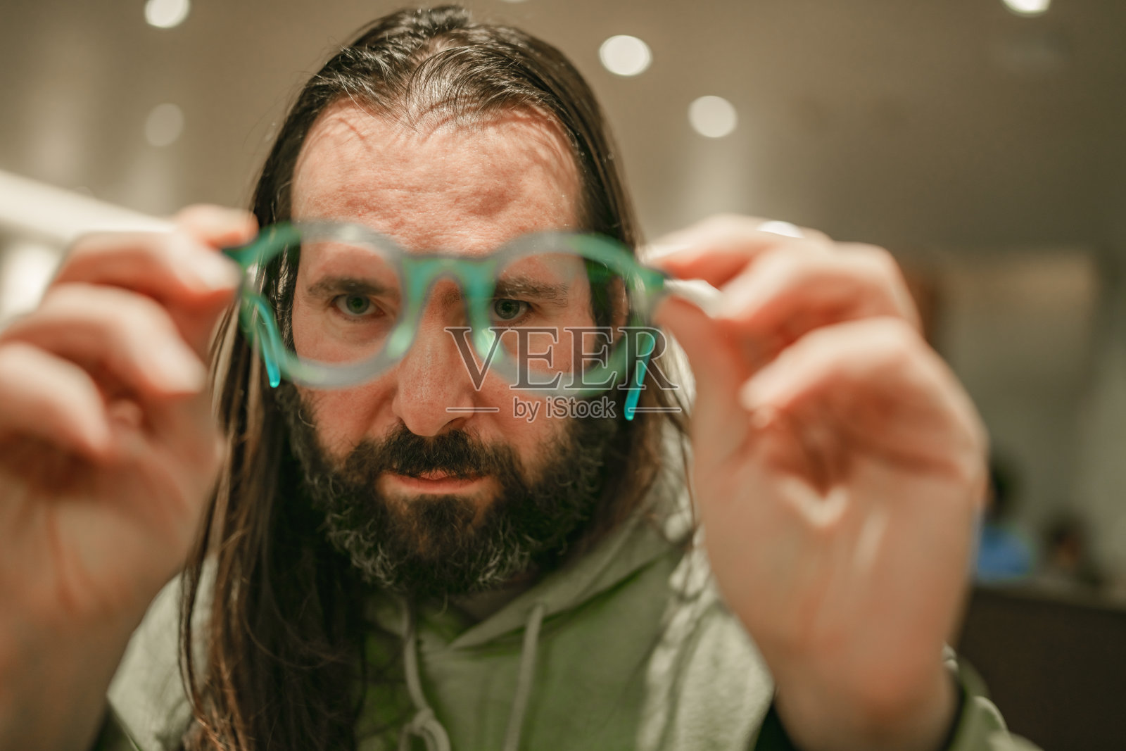 选择性聚焦于手中拿着眼镜的男人。照片摄影图片