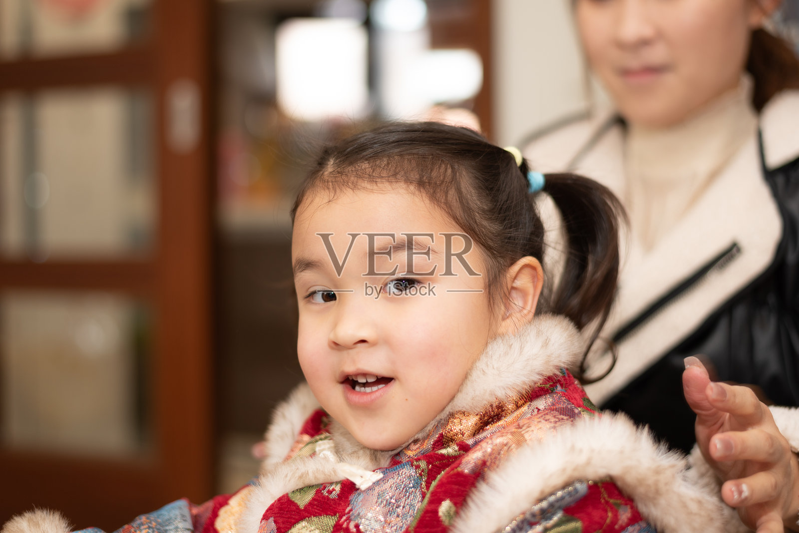 年轻的亚洲母亲为女儿扎头发照片摄影图片