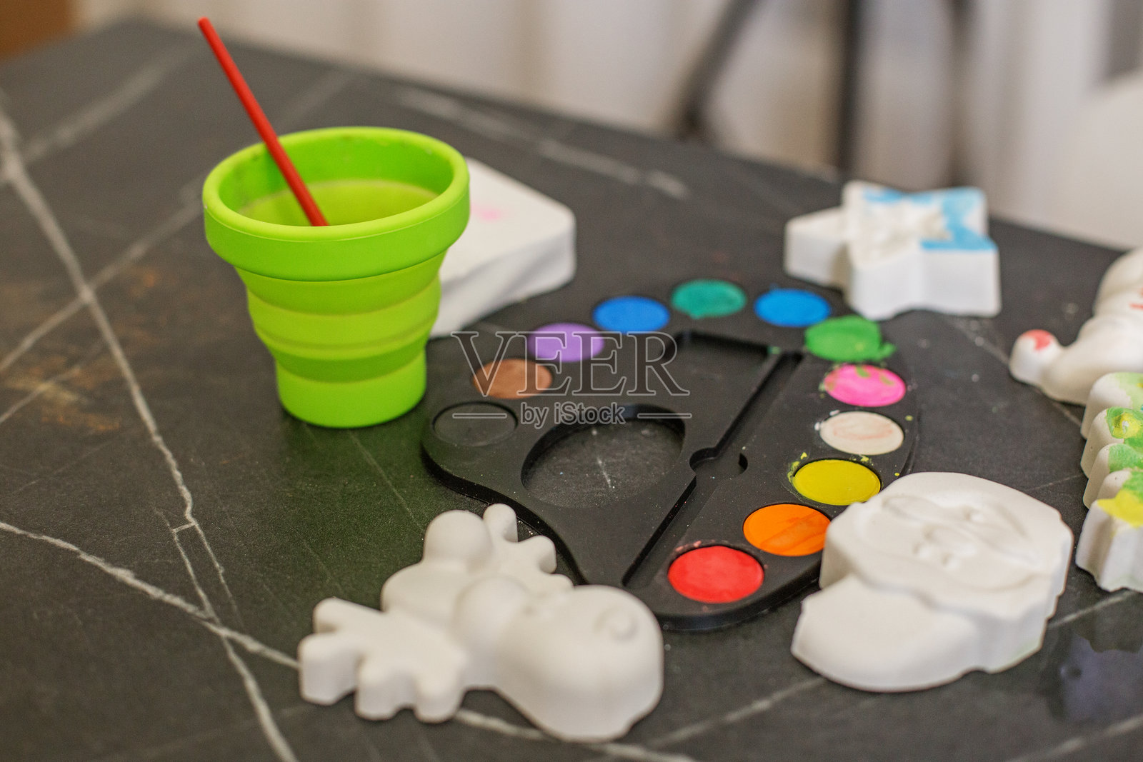 色彩缤纷的调色板和工艺材料整齐地摆放在桌子上，供创意活动使用照片摄影图片