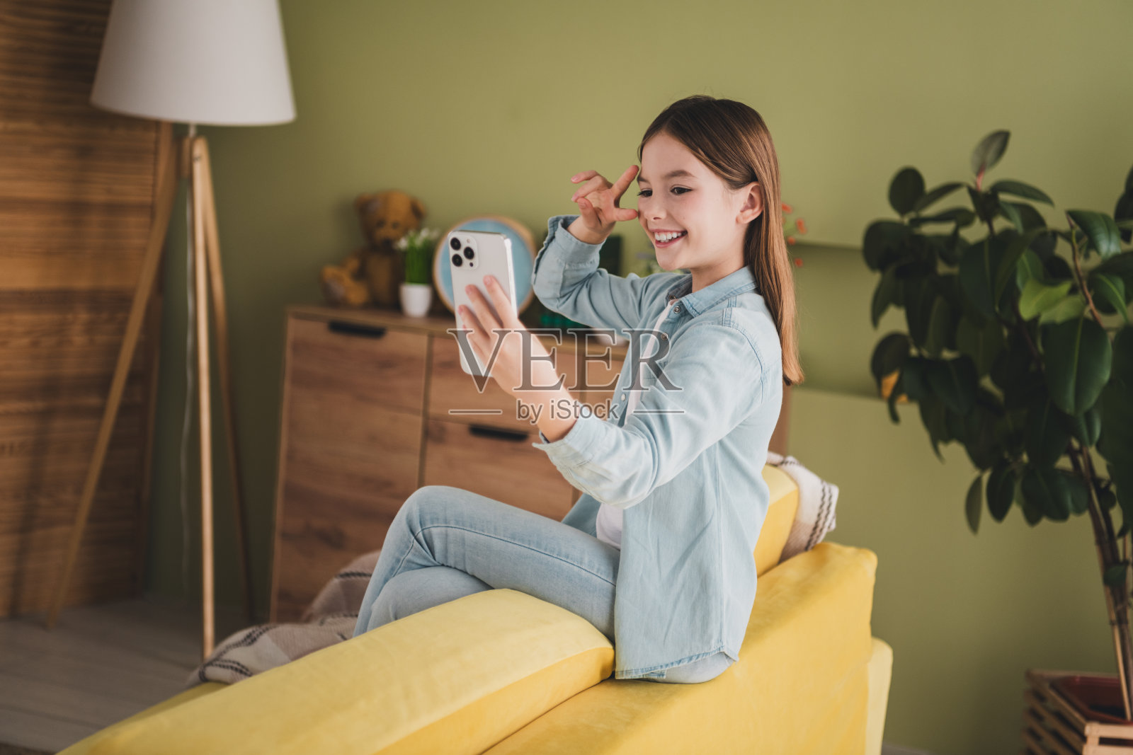 快乐的小女孩在阳光明媚的客厅里自拍照片摄影图片