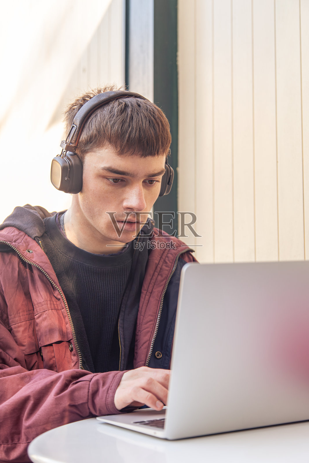 一名学生正在使用笔记本电脑学习。男学生在线学习。照片摄影图片