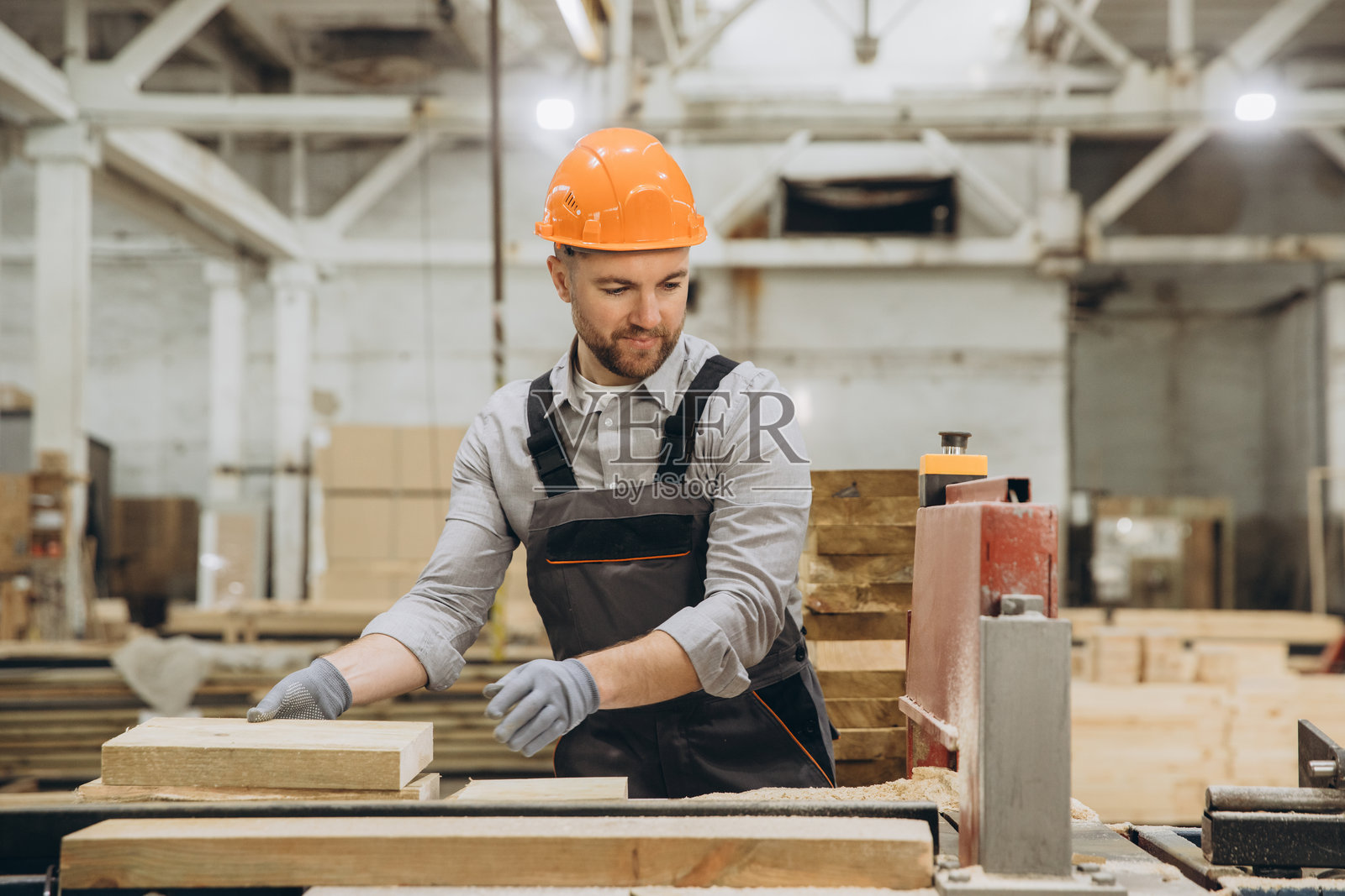 在家具厂中，木匠正在使用木板和锯子工作照片摄影图片