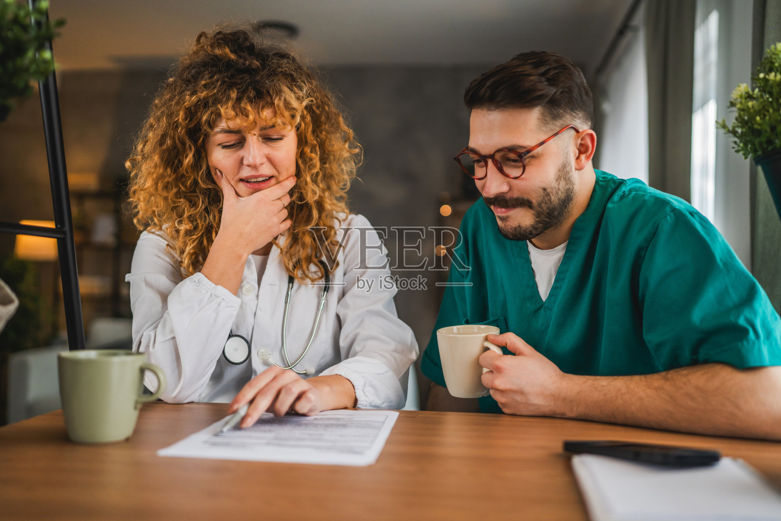 两位医生同事，男士和女士，一起审查病人档案。照片摄影图片