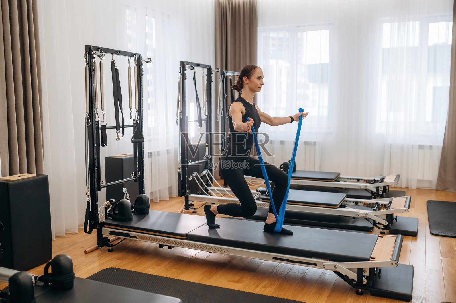 运动训练。年轻女性在健身房使用训练器材。照片摄影图片