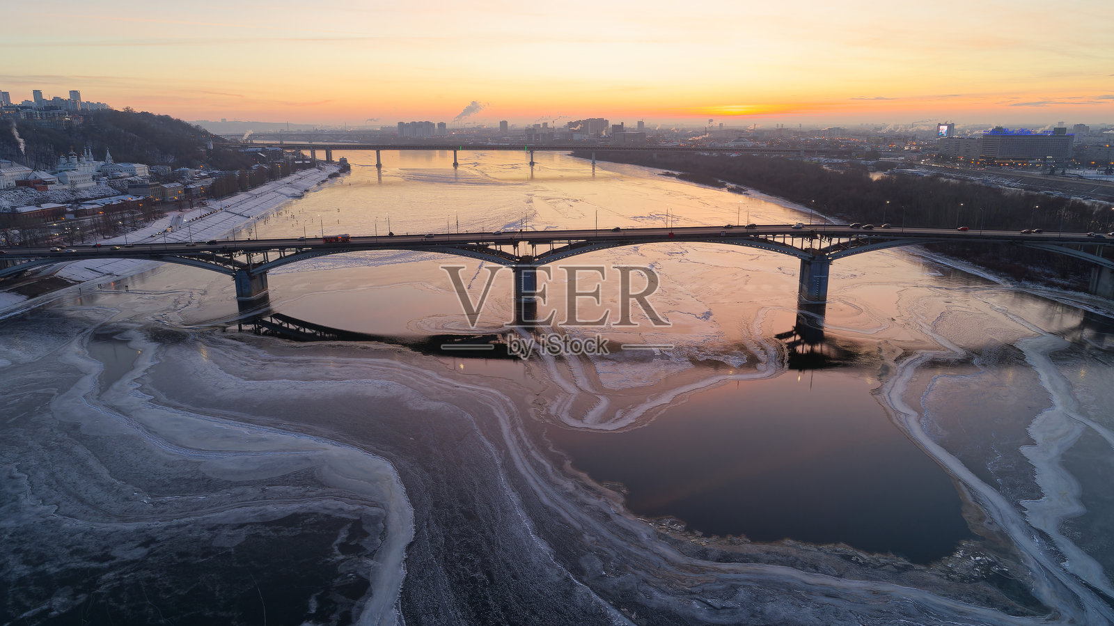 冰冻河上的桥梁与美丽的日落背景照片摄影图片