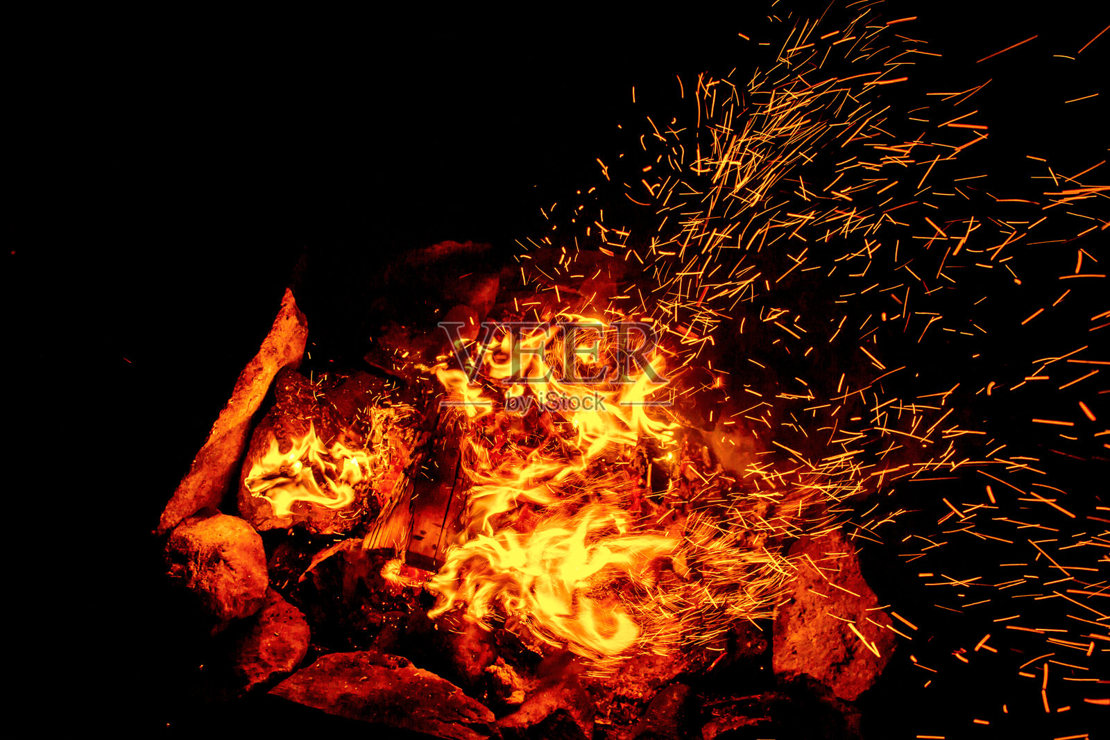 夜晚靠近篝火，火花四溅照片摄影图片
