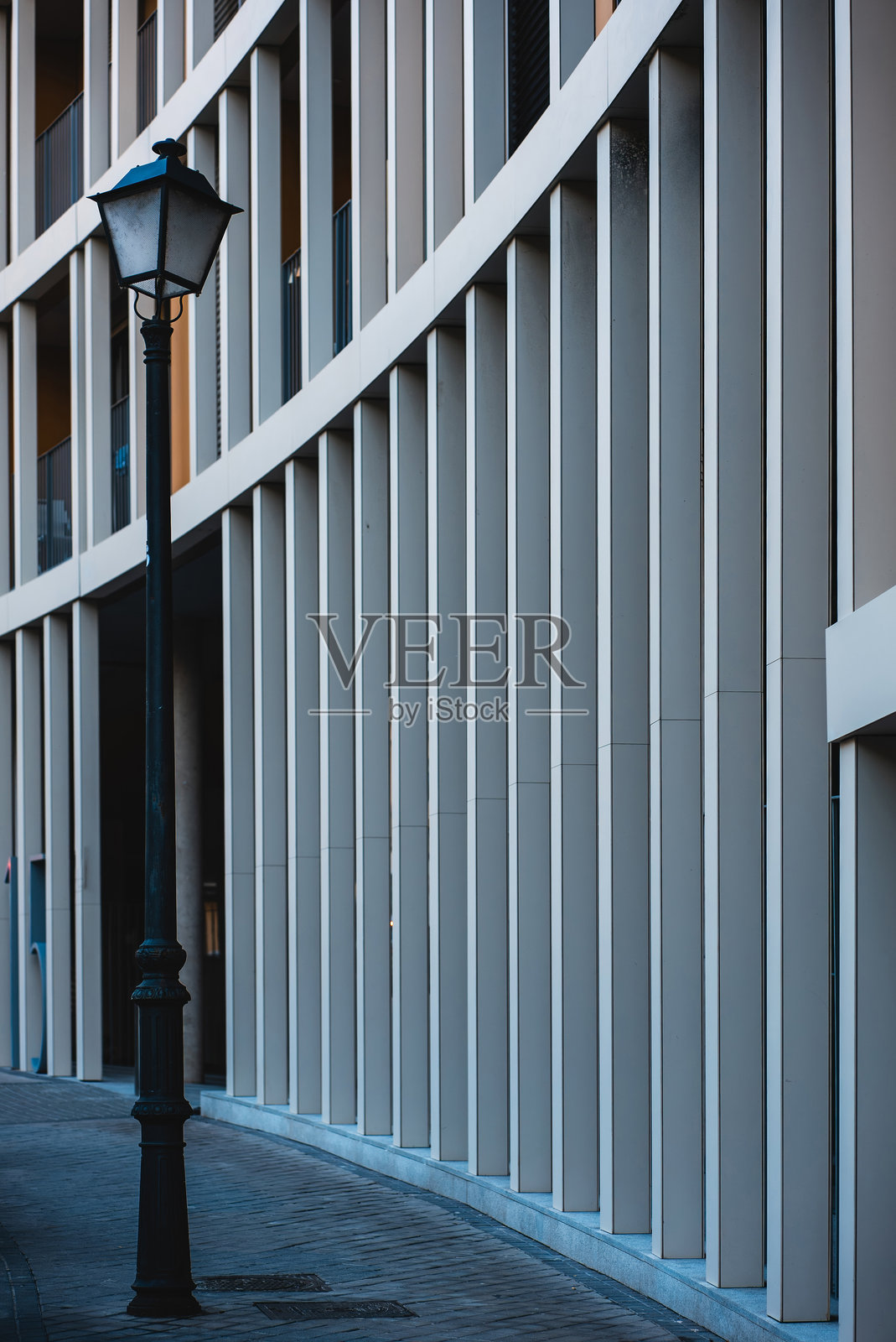 现代曲线建筑外立面，展现出节奏感的线条和窗户，位于城市环境中，沐浴在下午的阳光下照片摄影图片