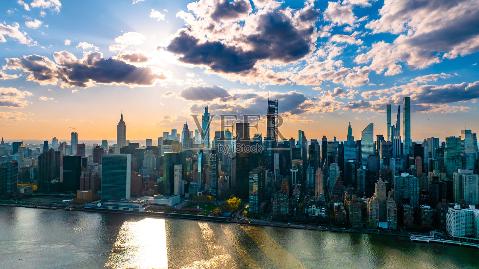 现代纽约的天际线。雄伟的摩天大楼在多云的白天水边矗立。照片摄影图片