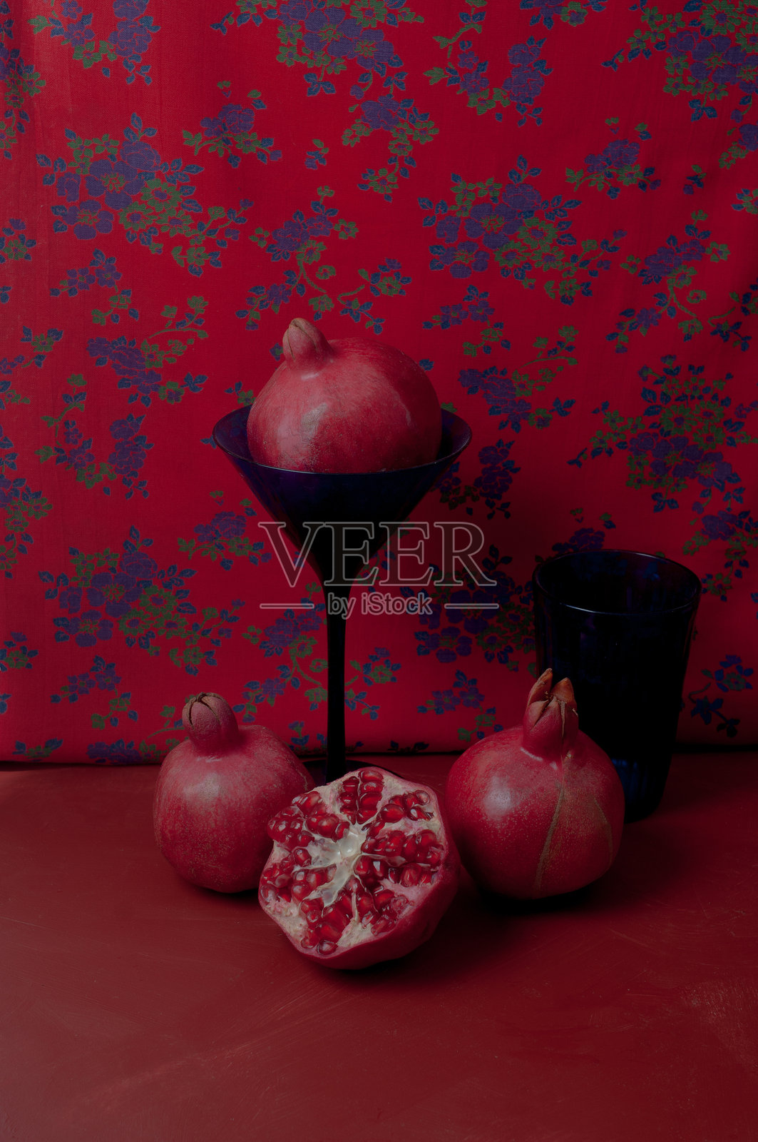手握石榴的复古红色背景静物画照片摄影图片