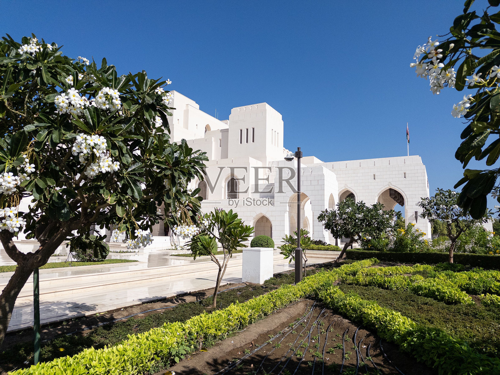 穆斯卡特皇家歌剧院的风景如画，展现了伊斯兰建筑和郁郁葱葱的花园。照片摄影图片