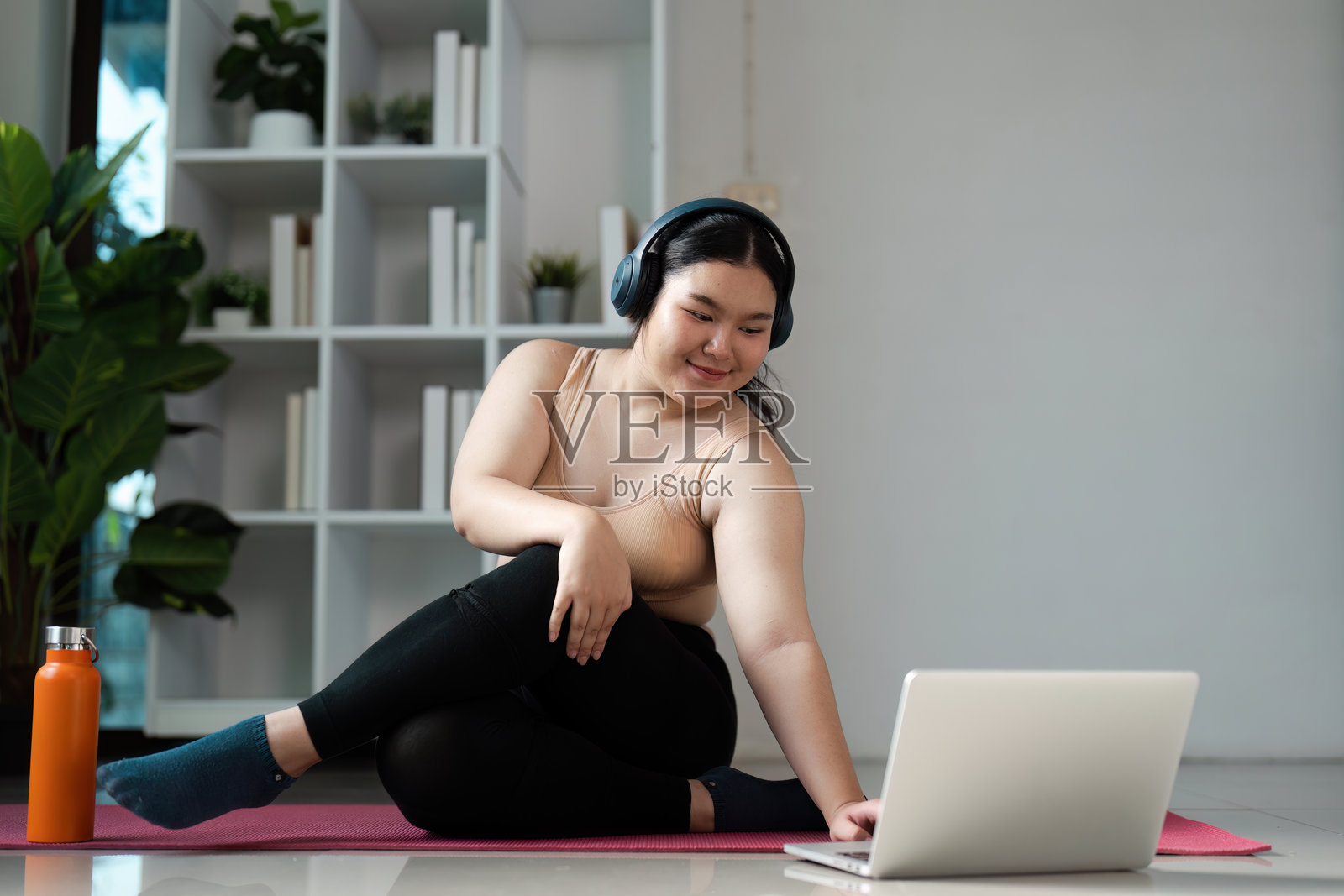 在家参加在线健康课程的超重女性，追求健康生活方式照片摄影图片