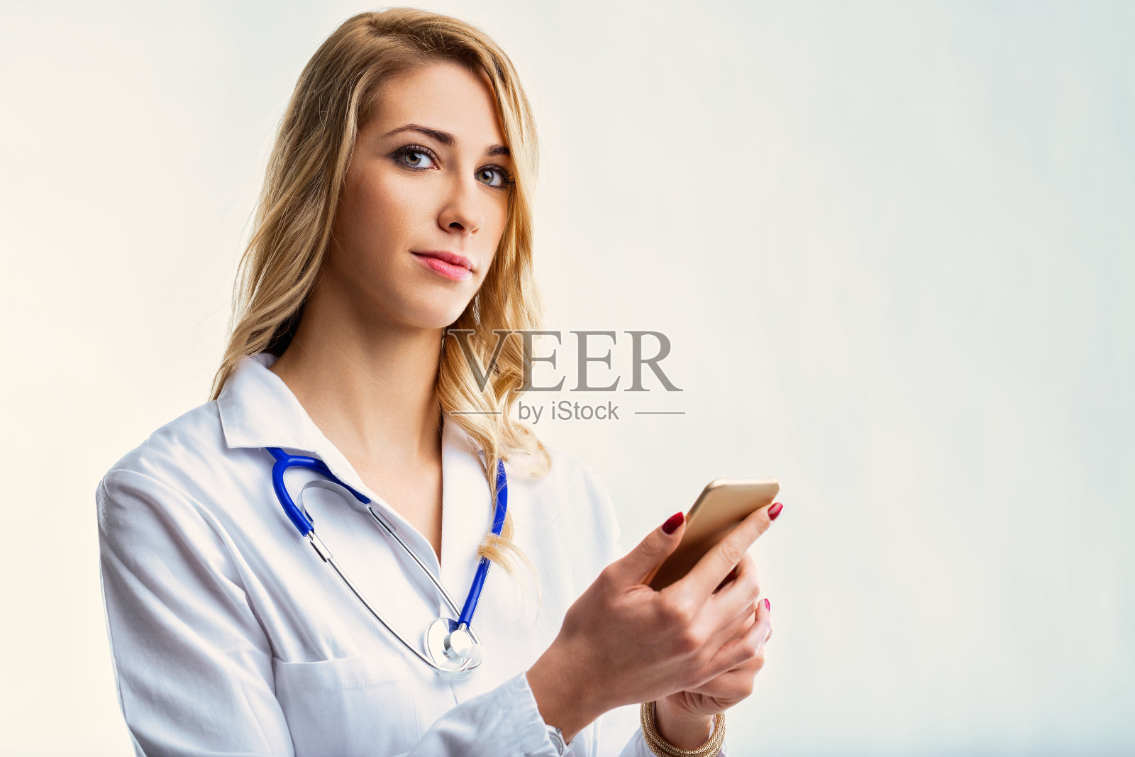 自信的医生在白色背景下使用智能手机照片摄影图片