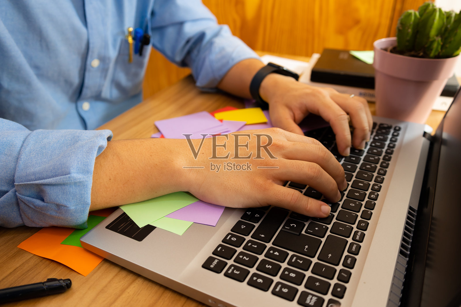 商人侧面视图正在笔记本电脑键盘上打字照片摄影图片