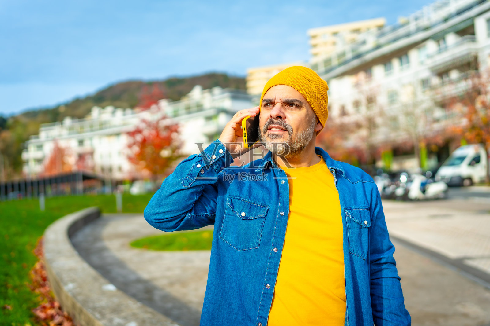 现代成熟男性在户外走路时与手机交谈照片摄影图片