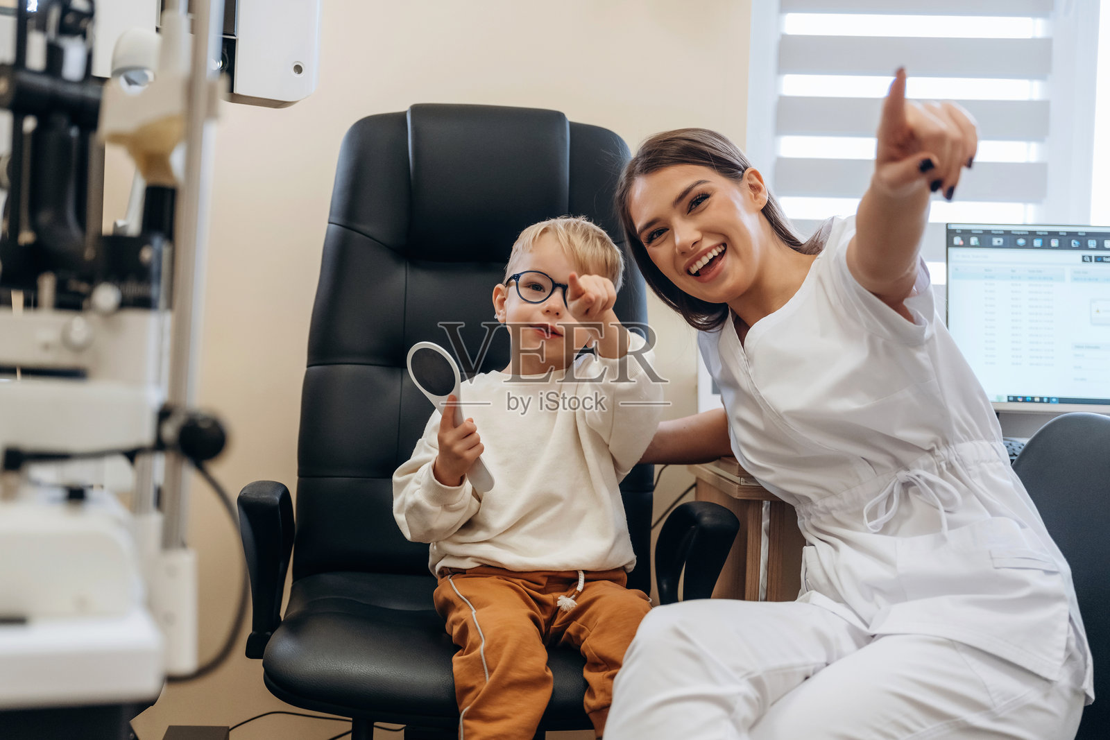 戴着眼镜的小男孩正在眼科医生的诊室里进行检查照片摄影图片