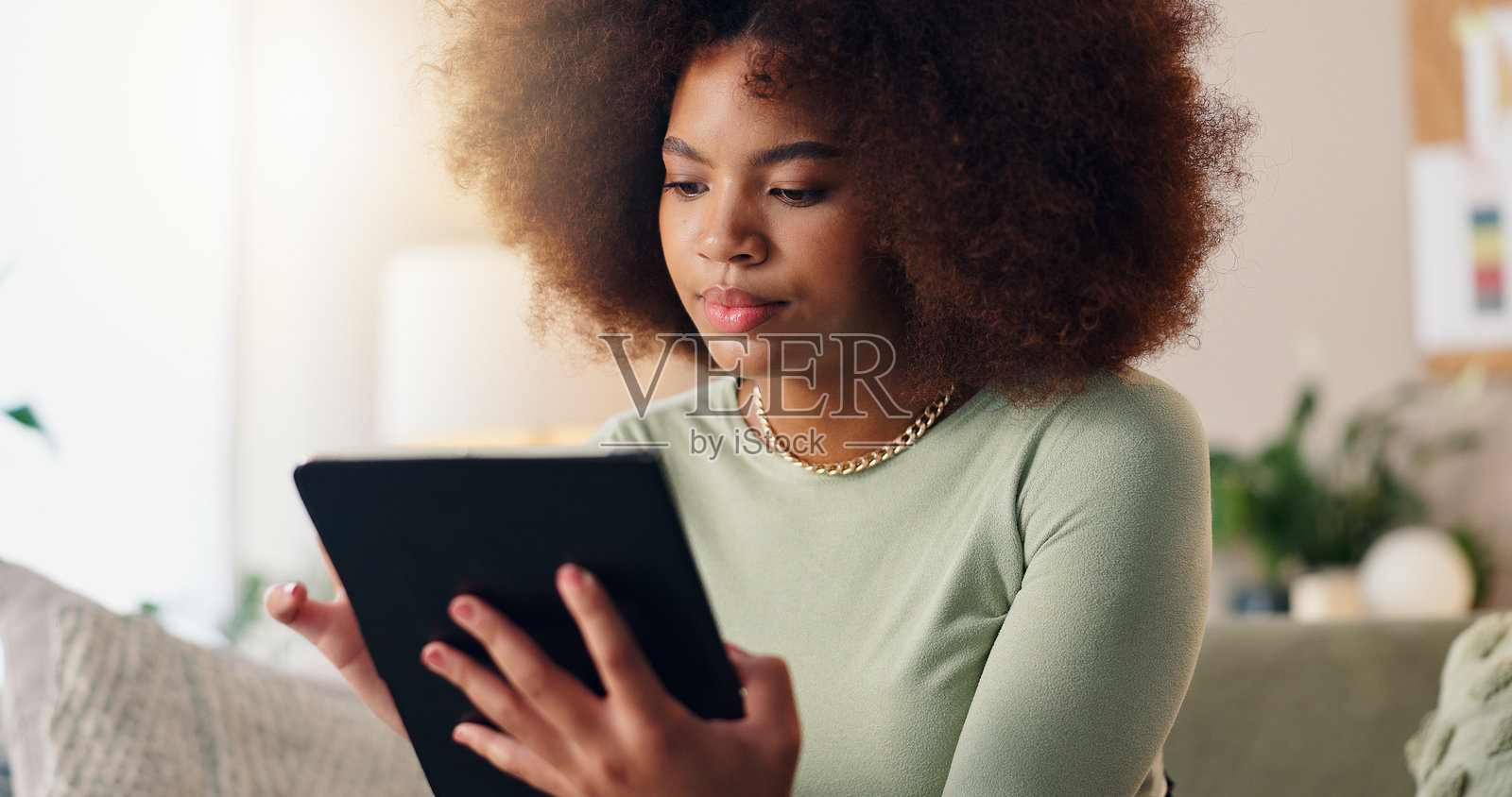 平板电脑、家居环境和非洲女性使用社交媒体，滚动浏览和学生在线阅读大学文章。数字、互联网和博客应用的网络搜索，科技和带有电子邮件的客厅。照片摄影图片