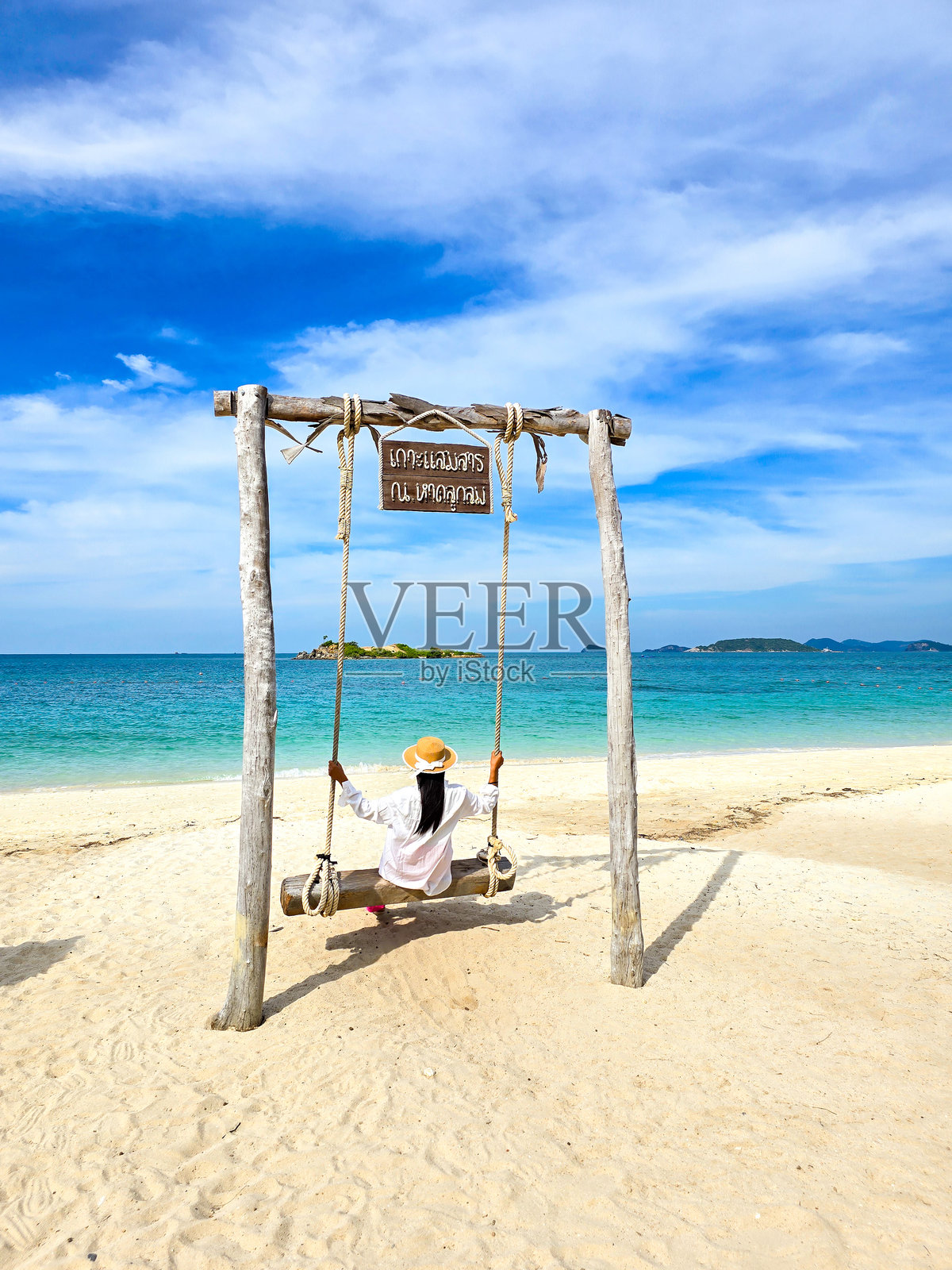在泰国萨迈山岛的海滩秋千上，在阳光明媚的天空下放松。照片摄影图片