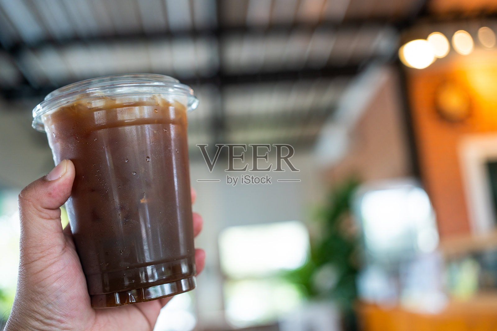 男人手中拿着外卖冰黑咖啡照片摄影图片