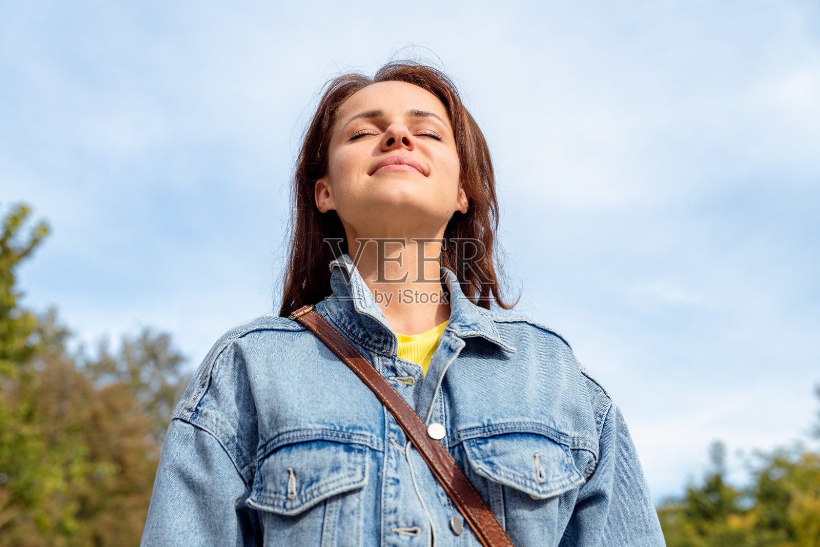 快乐健康的年轻城市女性在户外闭眼呼吸。照片摄影图片