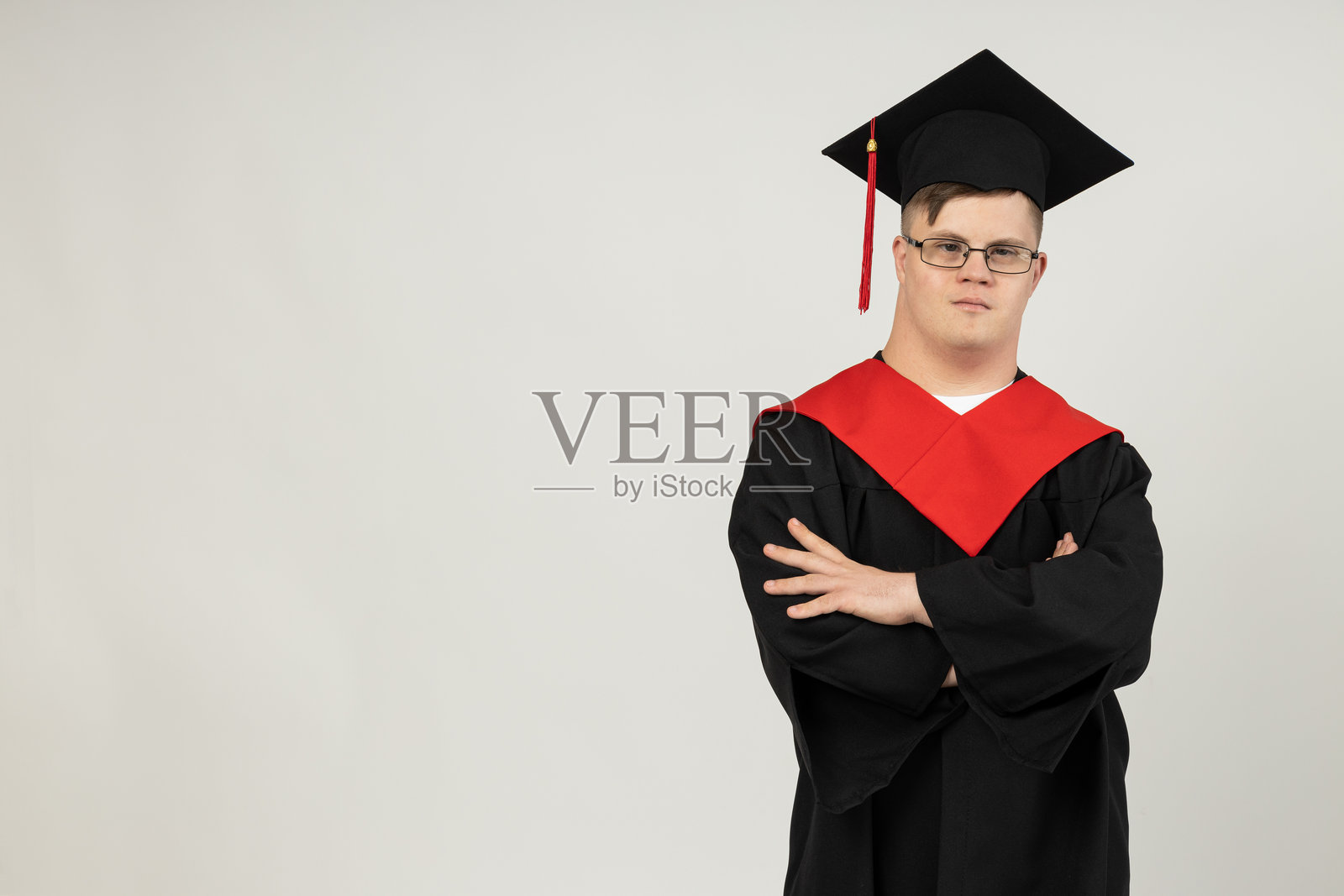 微笑的年轻人，戴着眼镜，穿着毕业西装，患有脑瘫。世界遗传疾病日概念，留有文字空间。照片摄影图片