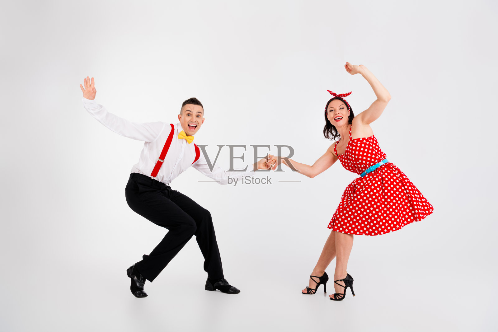 两位伴侣在白色背景下手牵手参加舞蹈比赛的全身照片照片摄影图片