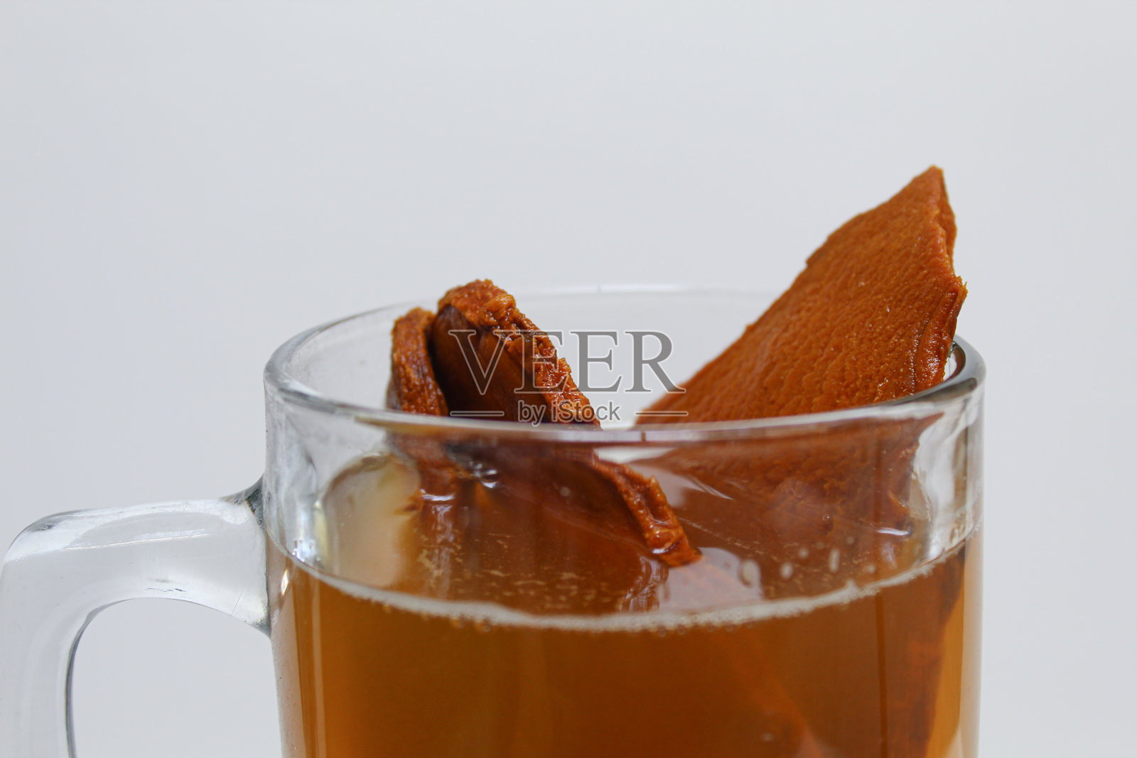 一杯特木拉瓦克饮料。特木拉瓦克或称为姜黄或爪哇姜黄。放在透明玻璃杯中，背景为白色。照片摄影图片