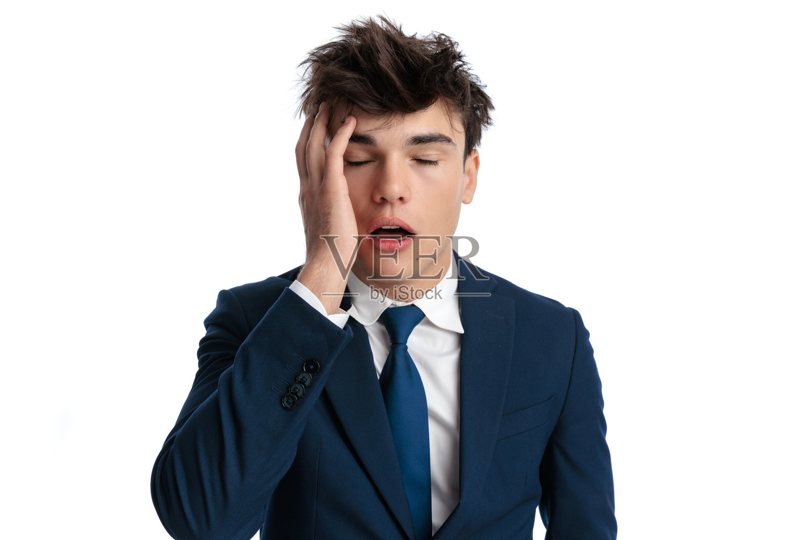 无聊的年轻商人用手掌撑着脸，显得不感兴趣。照片摄影图片