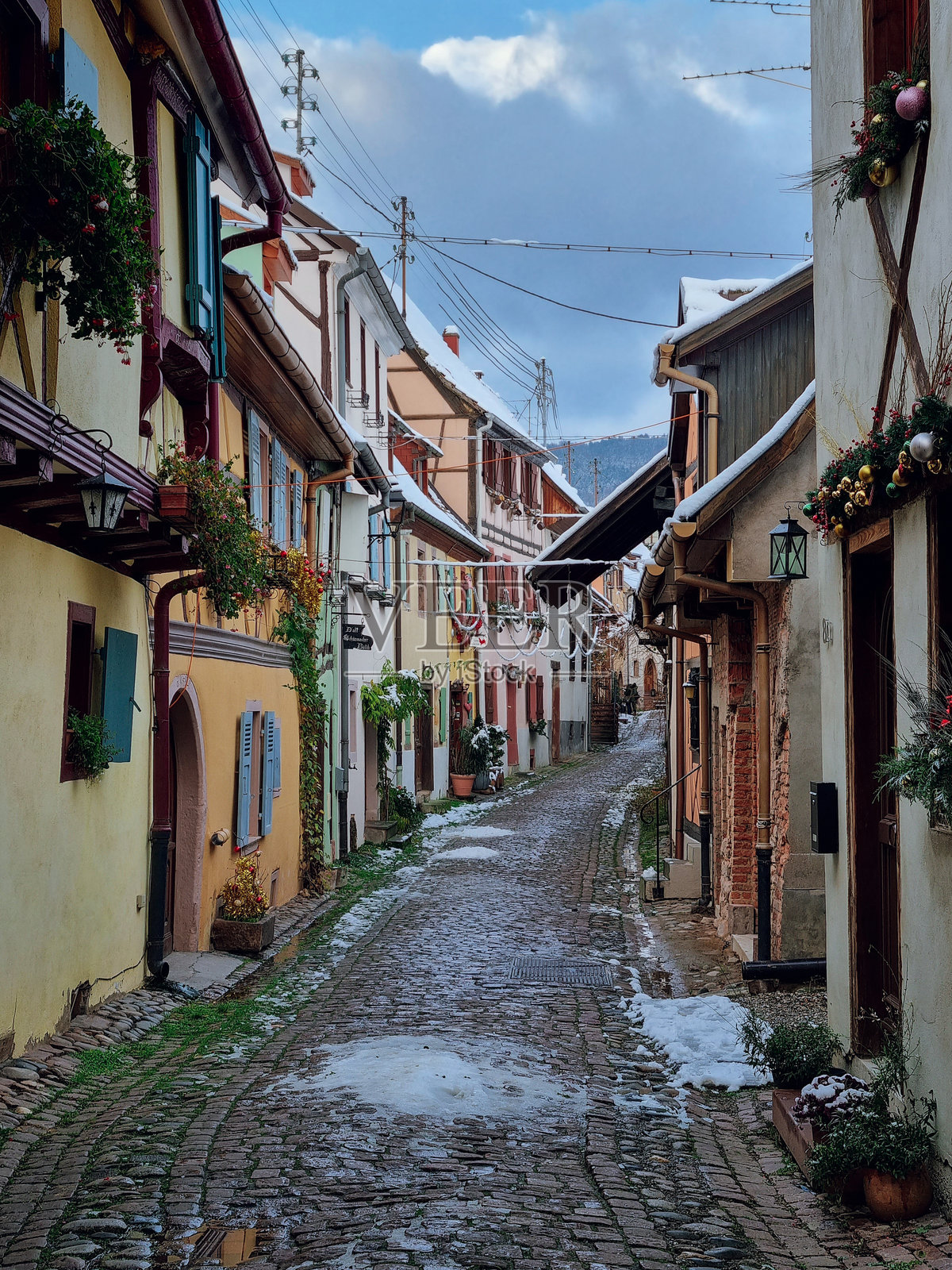 埃基斯海姆的圣诞装饰 - 迷人、色彩斑斓的雪-covered鹅卵石街道，半木结构房屋和五彩斑斓的外立面，法国最美丽的村庄，阿尔萨斯地区，法国照片摄影图片