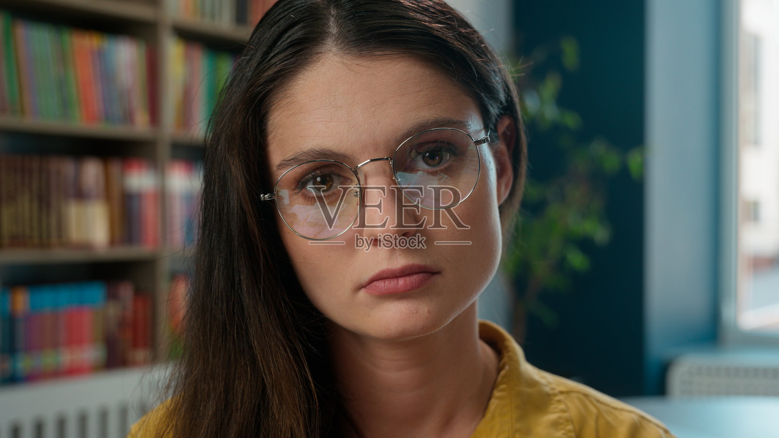 忧伤、担忧、疲惫、精疲力竭的白人女孩，高中学生，老师无助，压力大，书本堆积，学习、上大学、图书馆，面临问题，过度工作，手握教材，寻求帮助，教育负担过重。照片摄影图片