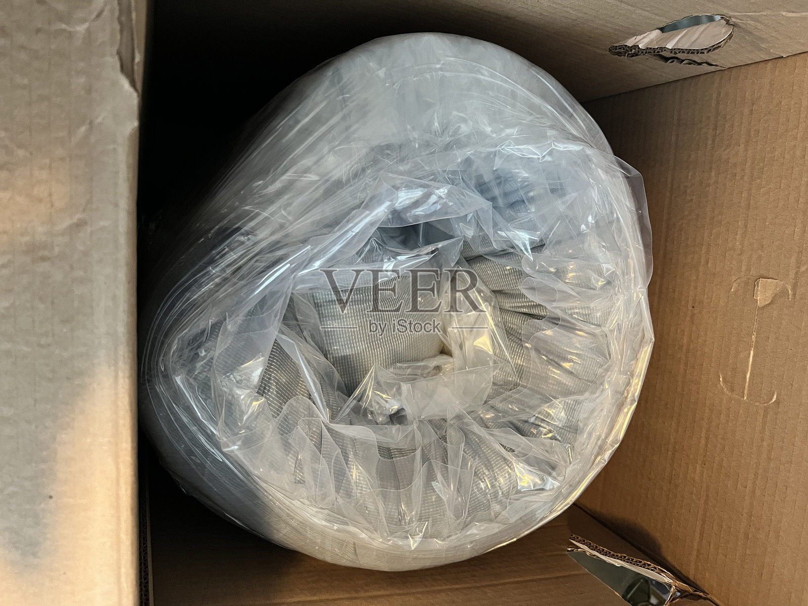 新床垫卷曲在盒子里照片摄影图片