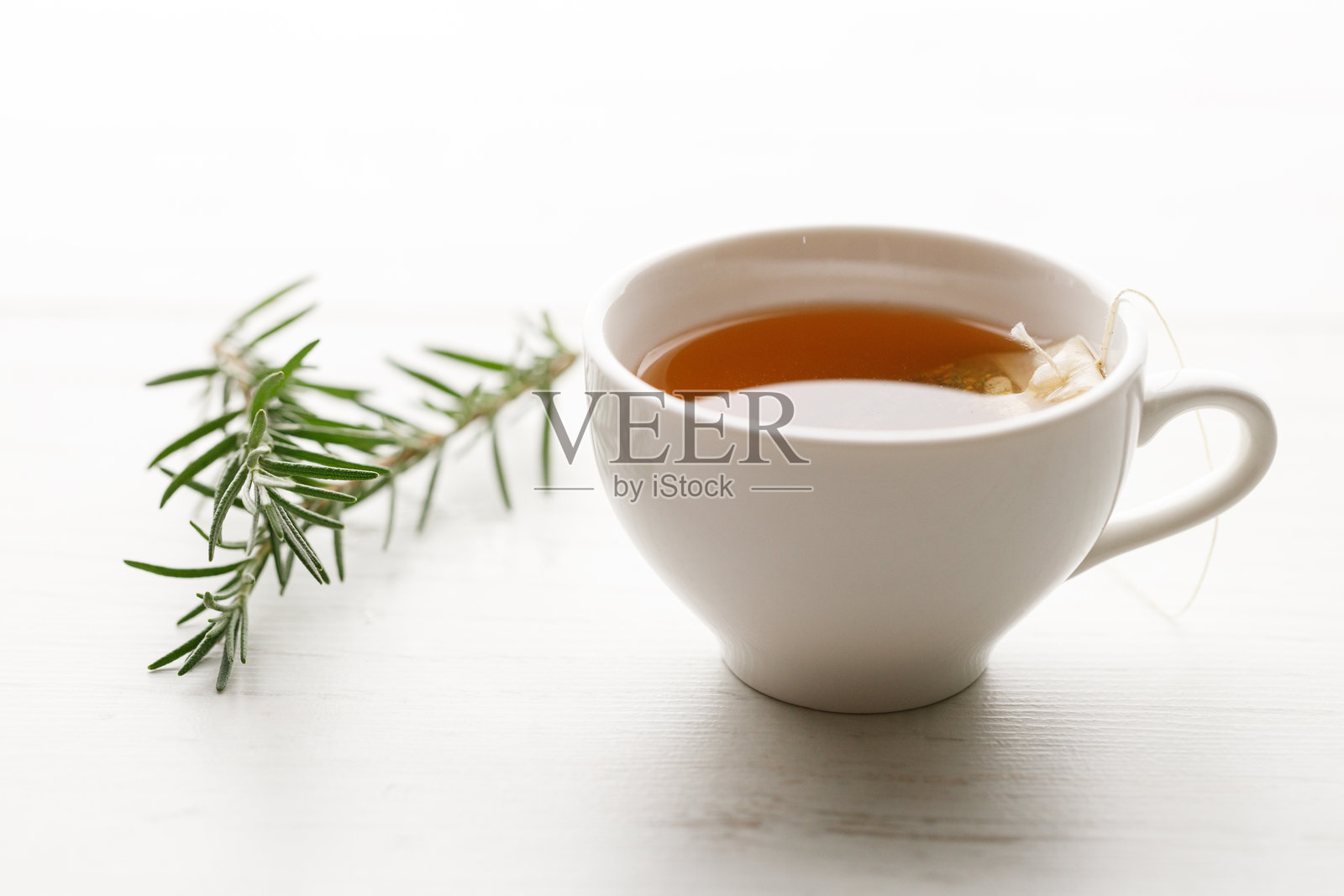 白色木桌上的一杯热茶，混合了南非红茶、薄荷、苹果和猴面包树果。照片摄影图片