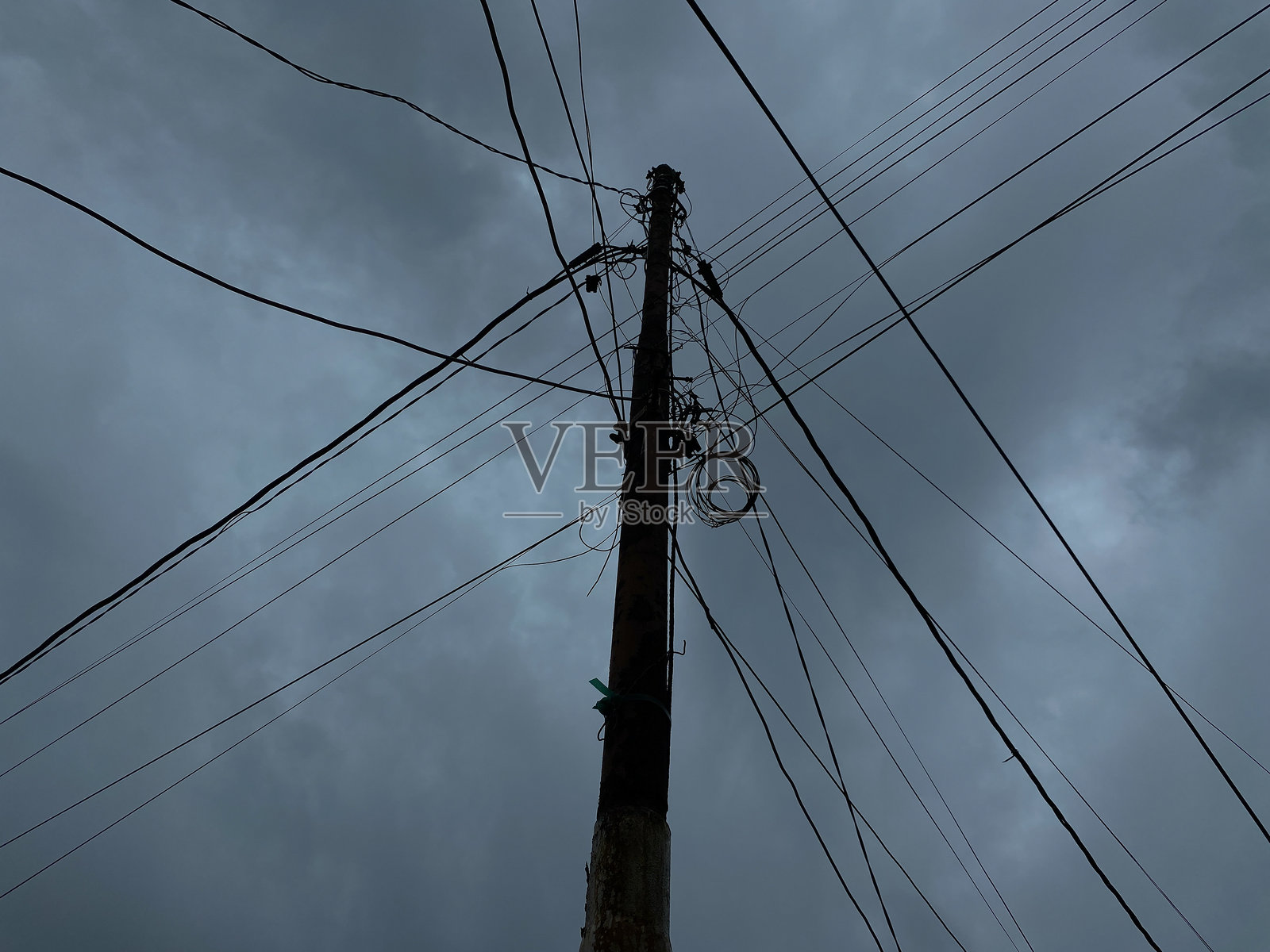 电力供应杆和电缆，背景是阴暗多云的天空照片摄影图片