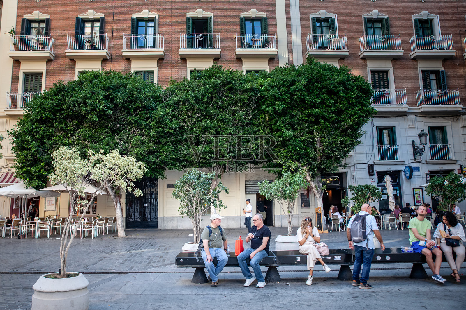 老年朋友，年长男性，在瓦伦西亚老城的长椅上随意聊天。西班牙人口正在老龄化。照片摄影图片