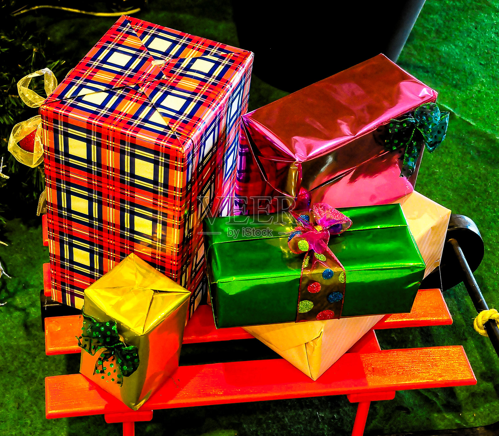 一堆五颜六色的礼物放在长椅上，其中一个是格子图案的盒子照片摄影图片