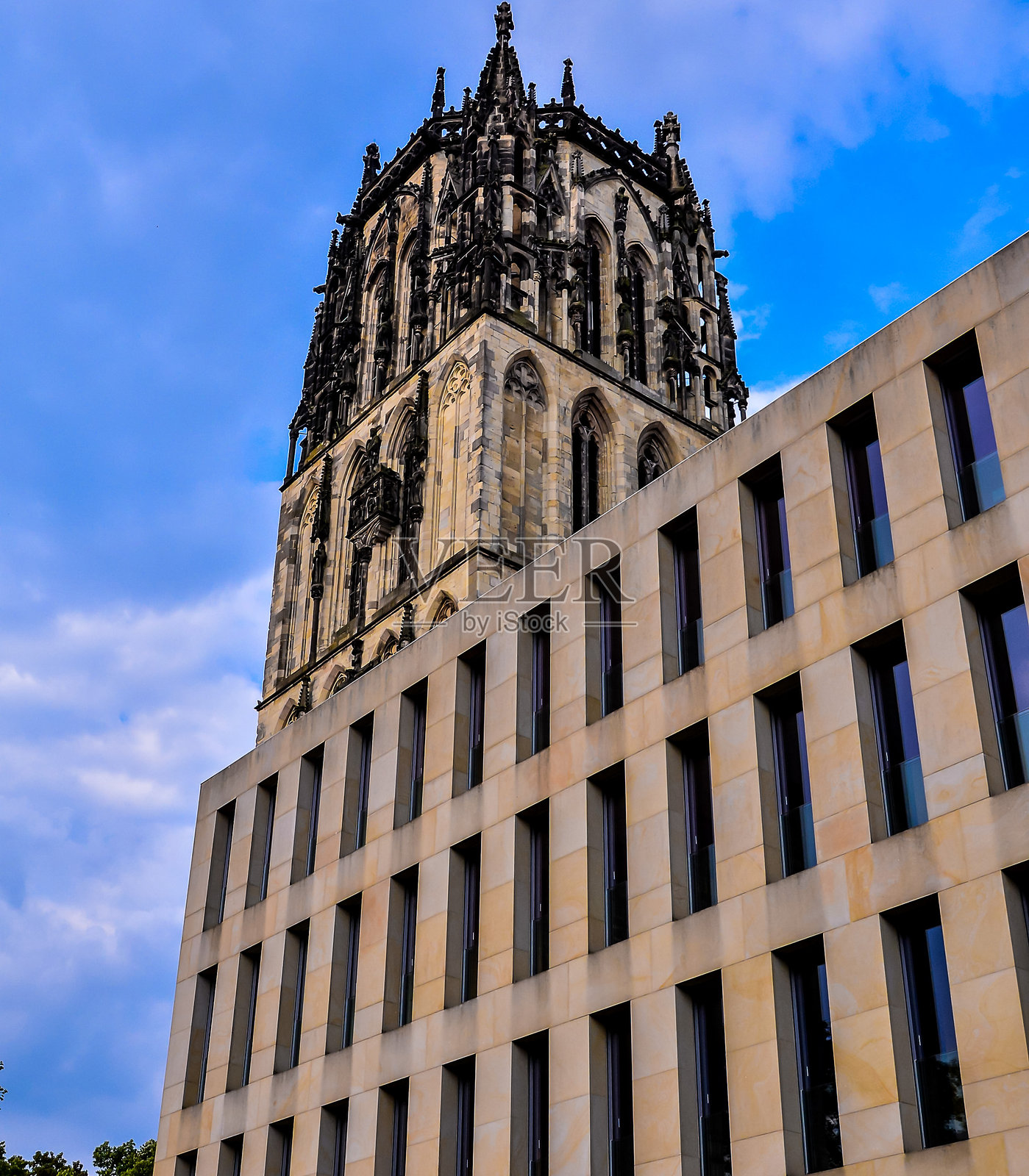 一座高楼与尖顶，背景是多云的天空照片摄影图片