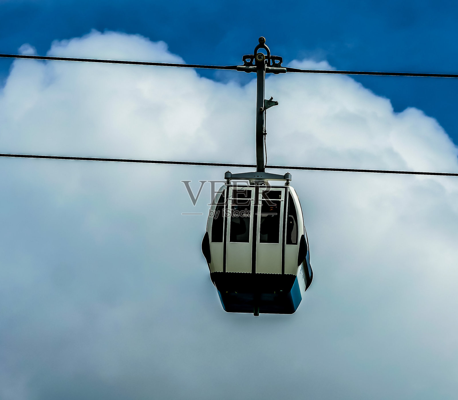 一辆缆车悬挂在多云的天空上照片摄影图片