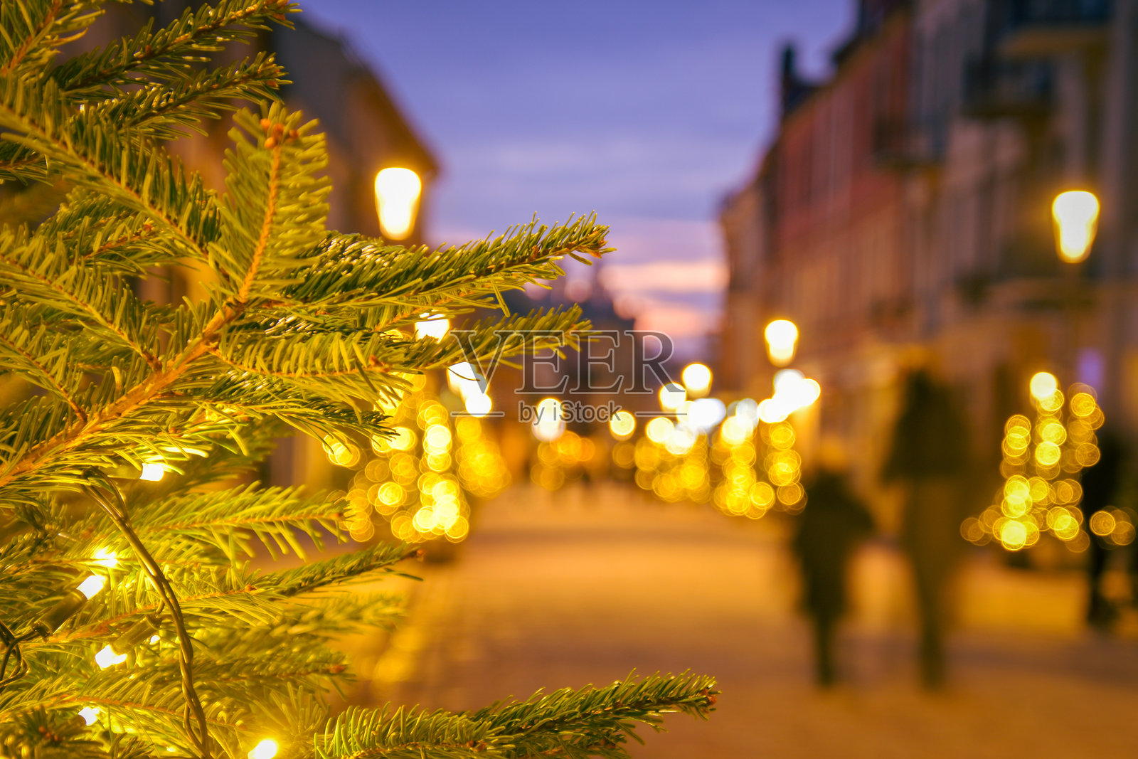 故意模糊的游客在欧洲街道上走动，周围是传统建筑，营造出家庭圣诞假期旅行的乐趣与探索观光的概念。照片摄影图片
